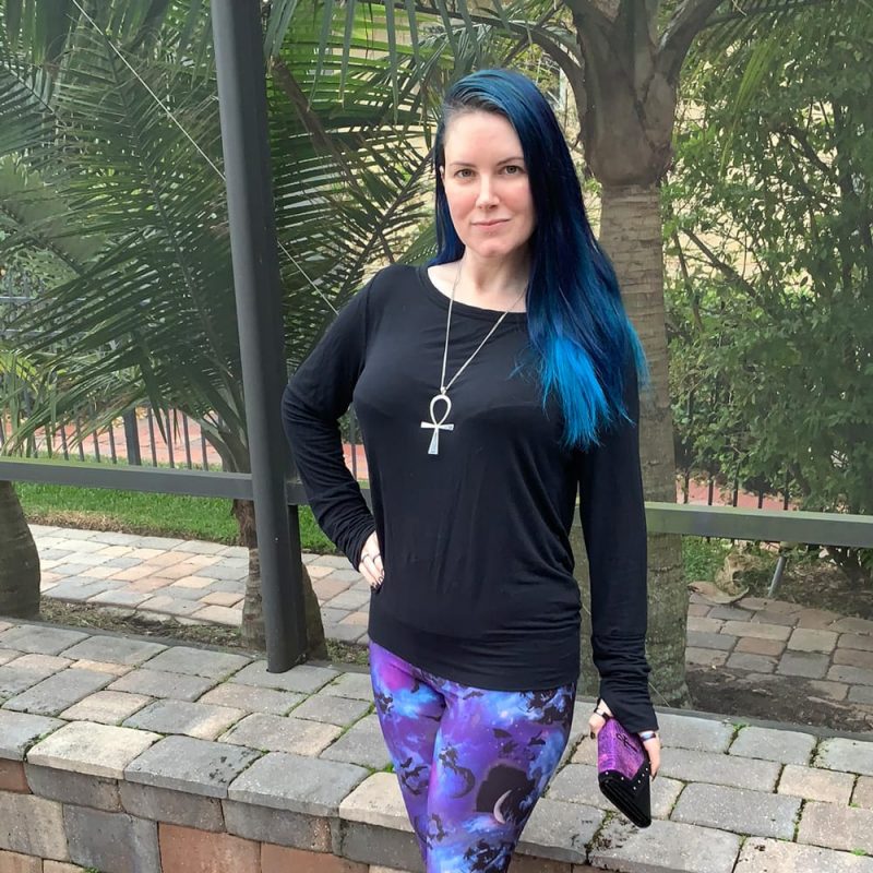 Courtney is wearing bat and skull galaxy leggings, a minimalist black top, pointed creepers, an ankh and carrying her Avelina De Moray Mahafsoun wallet
