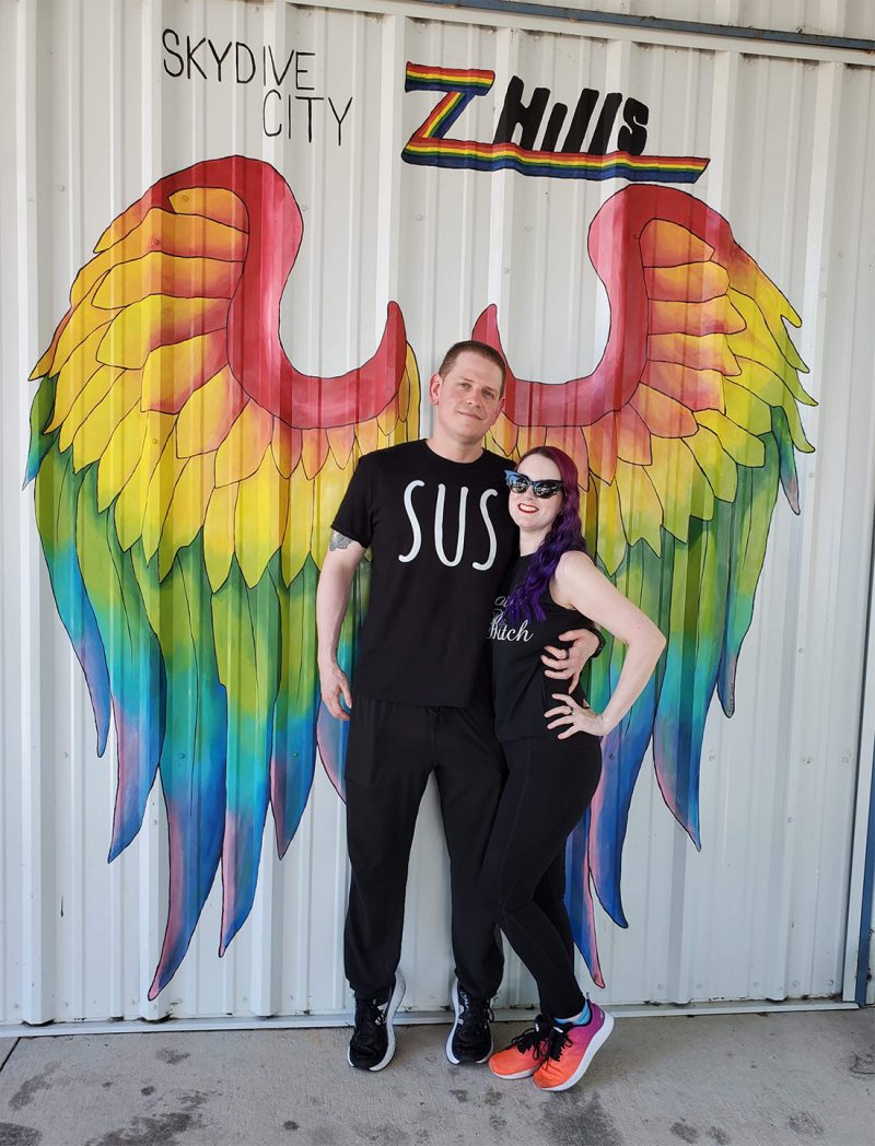 Dave and Phyrra in front of rainbow wings