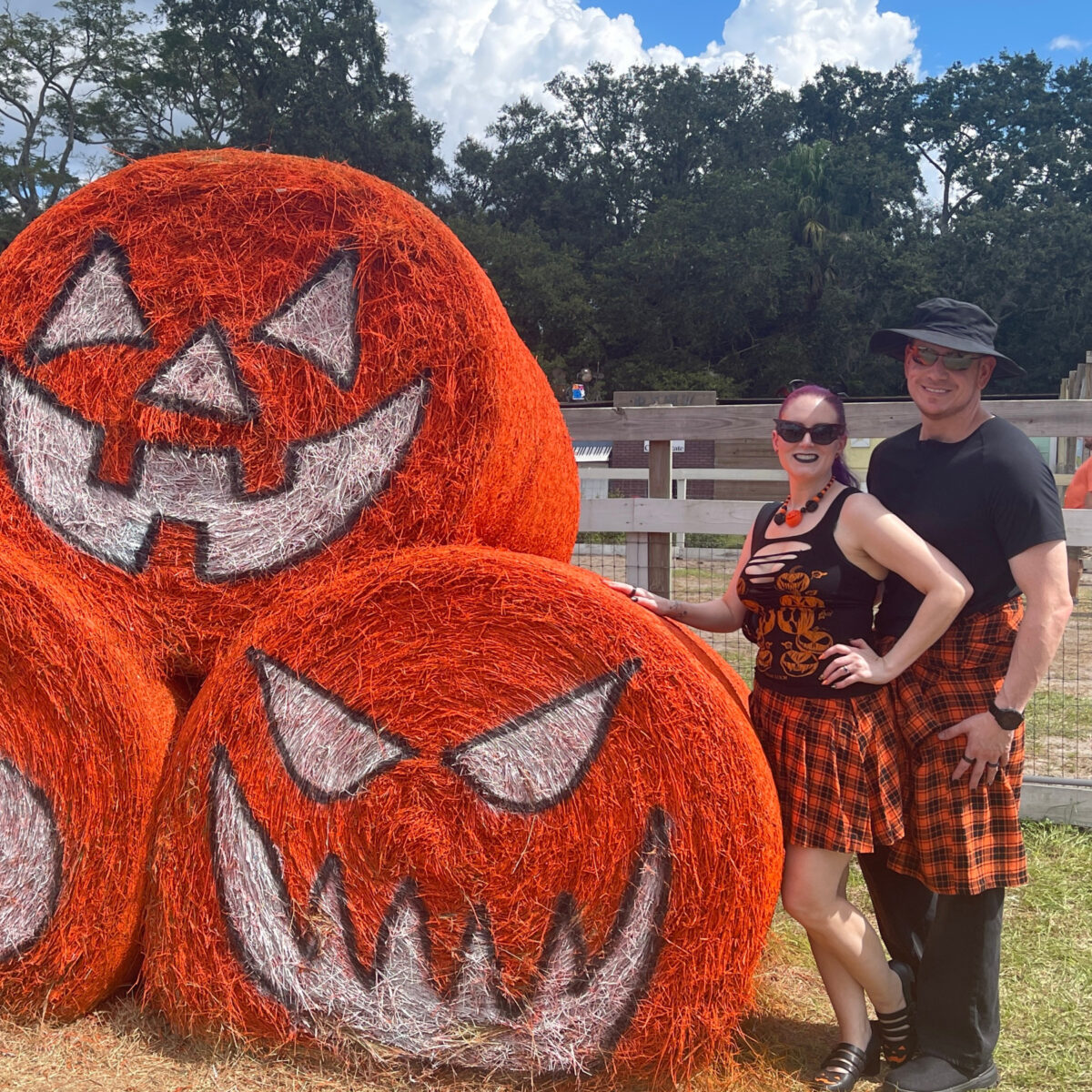 Cordelia and Dave by orange pumpkin hay bales