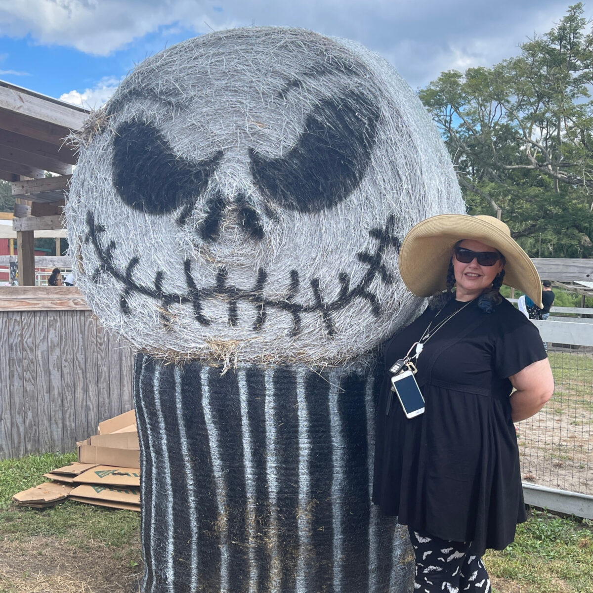 a Jack Skellington haybale with a gothic woman standing next to it