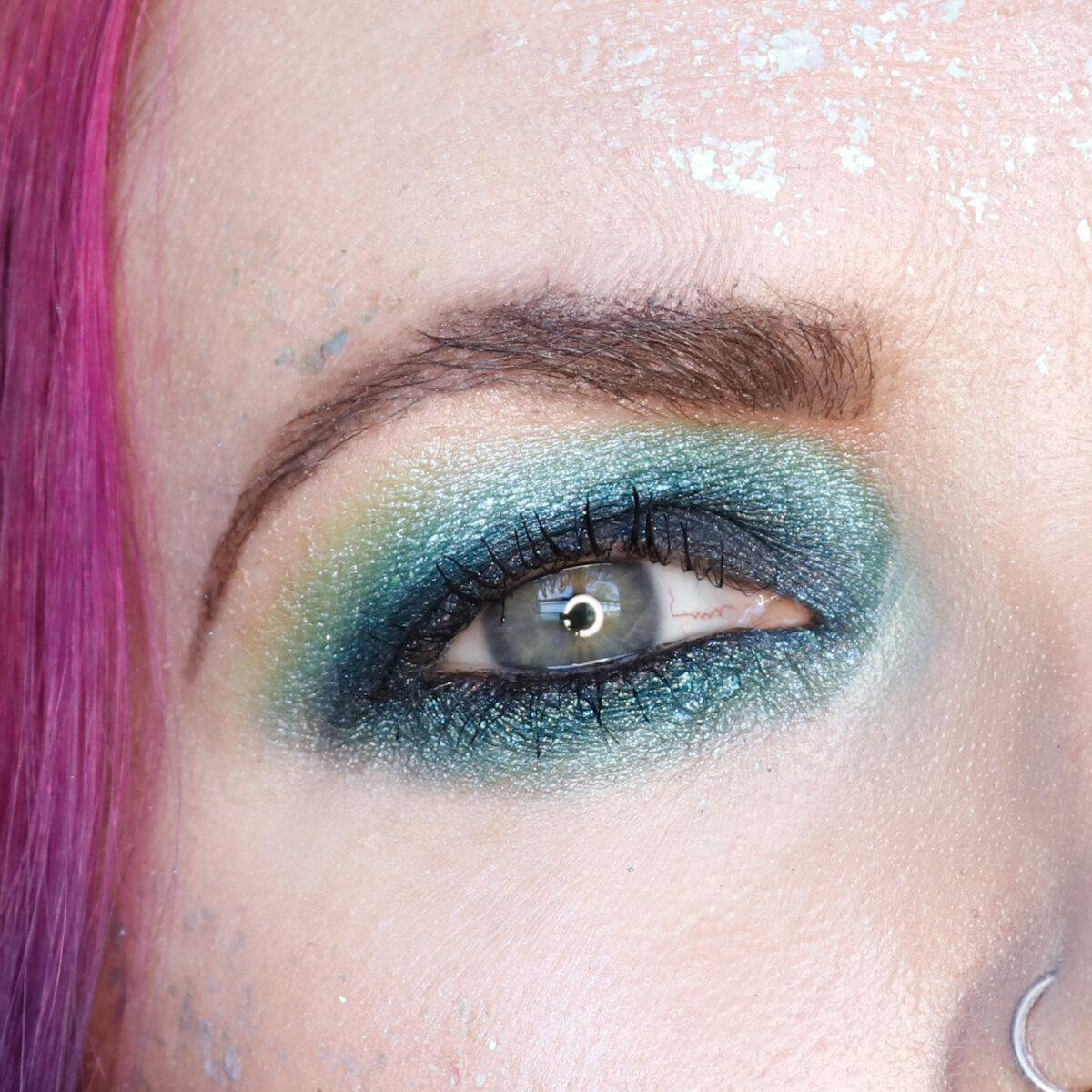 Lethal Cosmetics 1UP palette was used to create a black to navy blue to icy teal and green eye