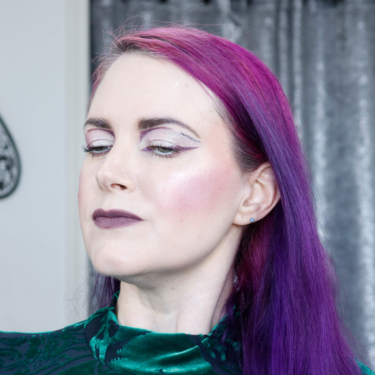 Cordelia is wearing purple blush with her graphic makeup look on hooded eyes
