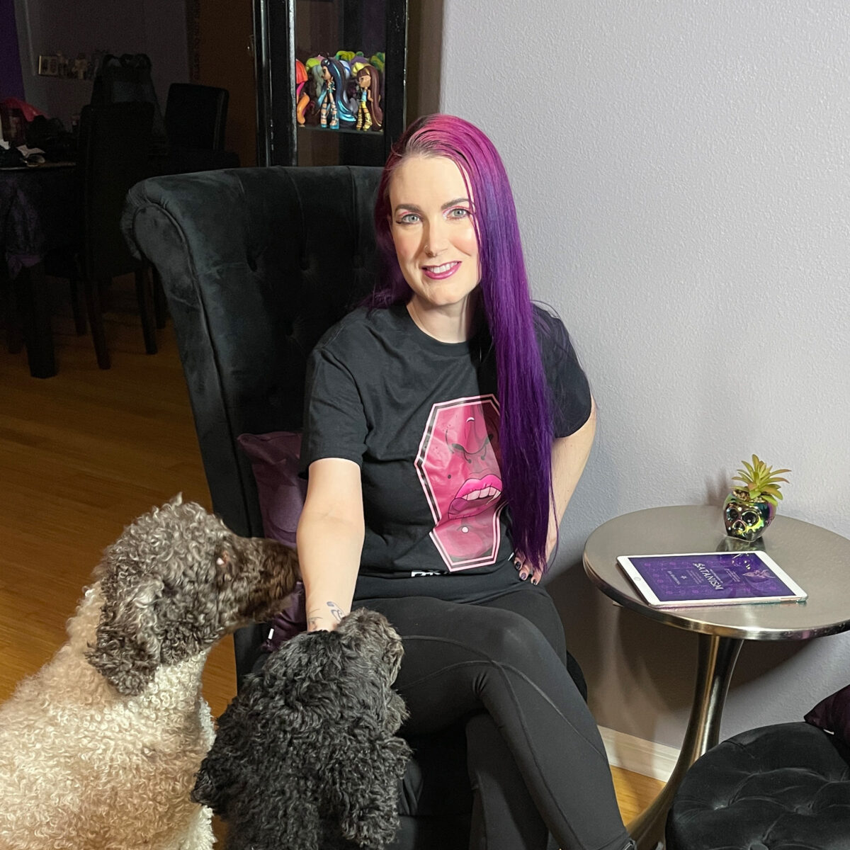 Amaya and Nyx, standard poodles, are standing next to seated Cordelia wearing a Bite Me shirt