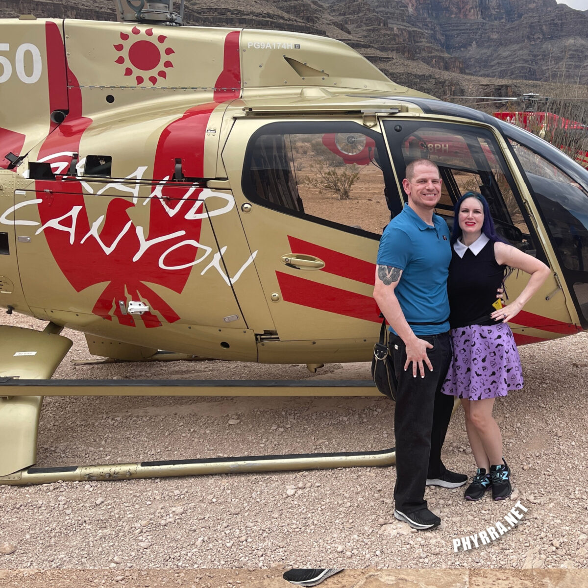 Cordelia and Dave standing in front of the anniversary helicopter