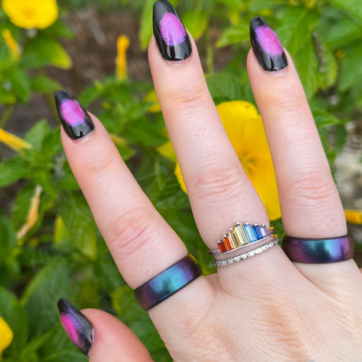 A gorgeous Rainbow Ring Pride flanked by black iridescent rings